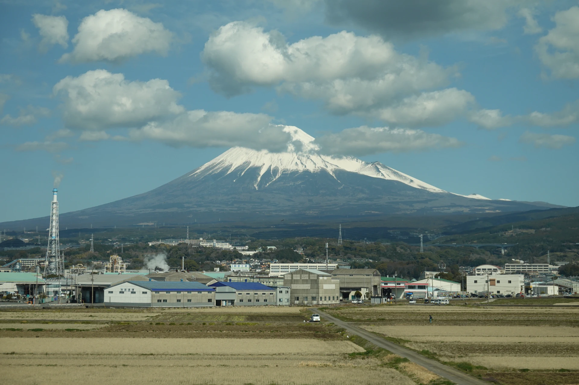 Mount Fuji glimpsed through the window of a moving Shinkansen bullet train.