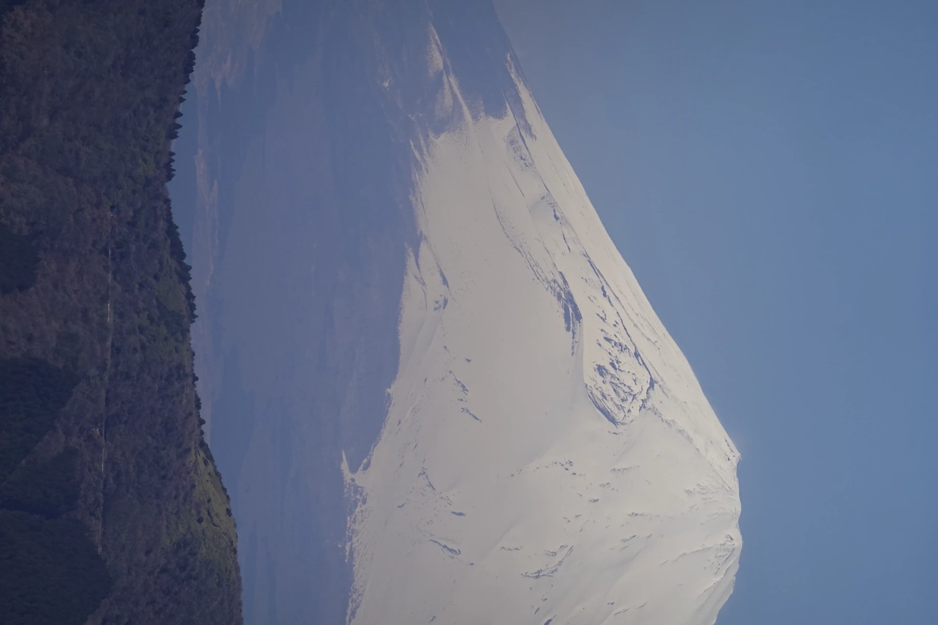 Mount Fuji rising above the horizon, photographed with a telephoto lens.